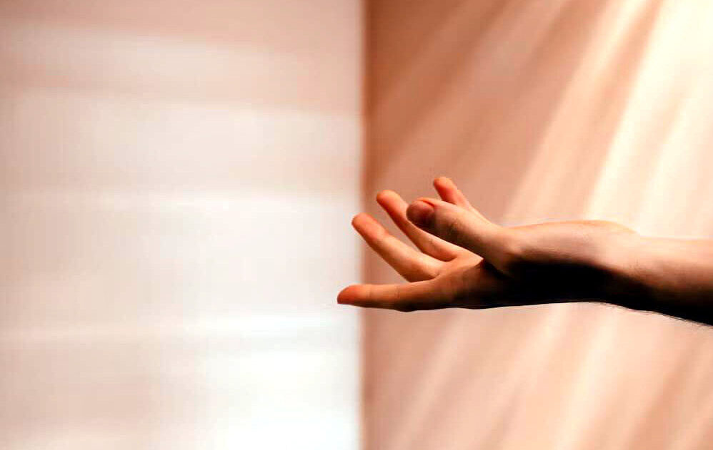 Offene Hand vor einem Hintergrund mit Sonnenstrahlen